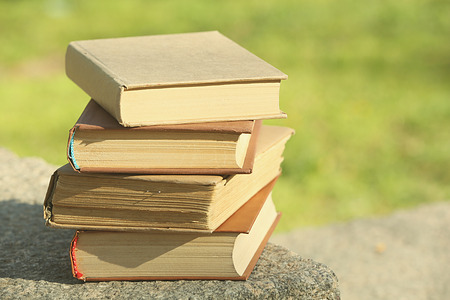 Stack of books outdoors, on blurred backgroundの写真素材