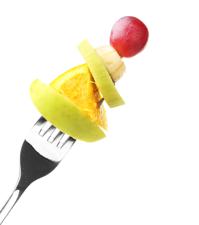 Snack of fruits on fork isolated on whiteの写真素材