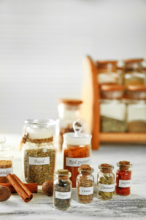Assortment of spices in glass bottles on wooden backgroundの写真素材