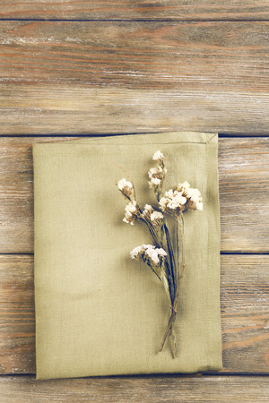 Beautiful dry flowers on napkin on wooden backgroundの写真素材