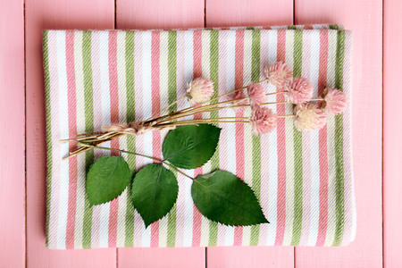 Beautiful dry flowers on napkin on wooden table close up