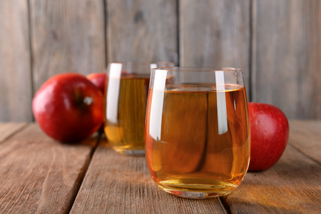 Glasses of apple juice on wooden backgroundの写真素材