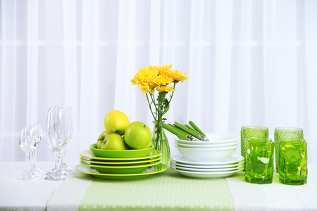 Colorful table settings and tulip flowers in vase on table, on light backgroundの写真素材