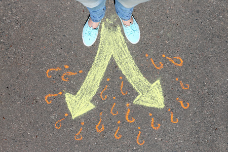 Female feet making choice on asphalt with drawing arrows, outdoorsの写真素材