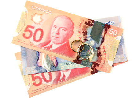 Golden wedding rings on banknotes, isolated on white. Marriage of convenienceの写真素材