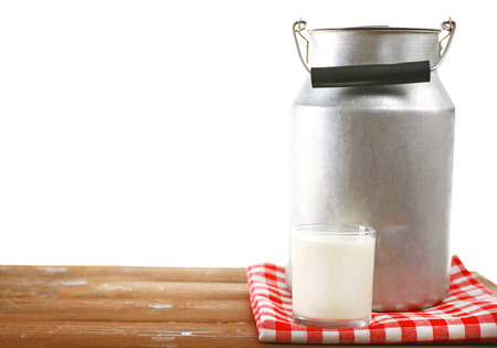 Retro can for milk and glass of milk on wooden table, on white backgroundの写真素材