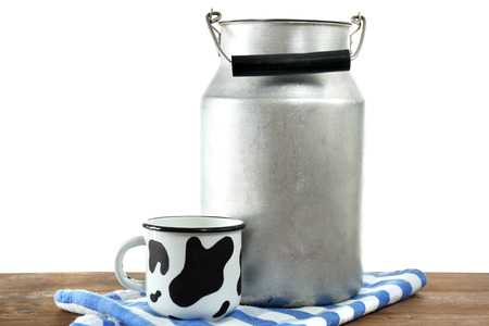 Retro can for milk and mug of milk on wooden table, on white backgroundの写真素材