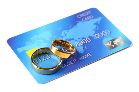 Golden wedding rings and credit card, isolated on white. Marriage of convenience conceptの写真素材