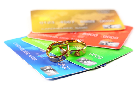 Golden wedding rings and credit cards, isolated on white. Marriage of convenience conceptの写真素材