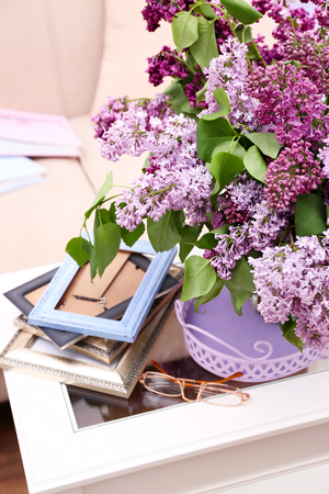 Beautiful lilac flowers in vase on table of interior backgroundの写真素材
