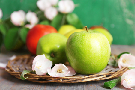 Fresh apples with apple blossom on wooden tableの写真素材