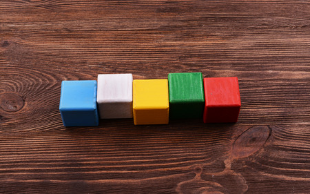 Colorful cubes for inscriptions on wooden background