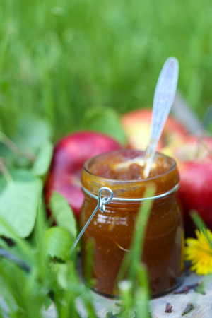 Apple jam in jar and fresh red apples on grassの写真素材