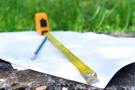 Building roulette and pencil on white sheets of paper, outdoorsの写真素材