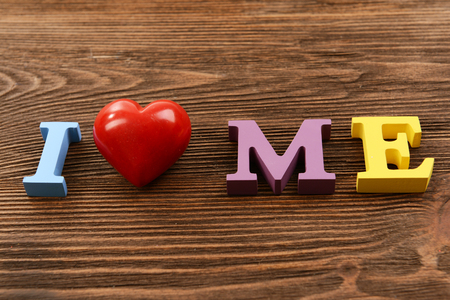Inscription I LOVE ME made of colorful letters on wooden backgroundの写真素材