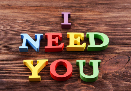Inscription I NEED YOU made of colorful letters on wooden backgroundの写真素材