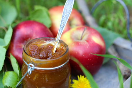 Apple jam in jar and fresh red apples on grassの写真素材