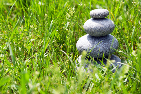 Stack of spa stones over green grass backgroundの写真素材