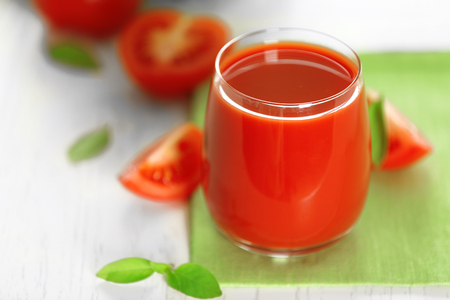 Tomato juice and fresh tomatoes on wooden table close-upの写真素材