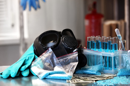 Drug laboratory: blue  methamphetamine and money on table close upの写真素材
