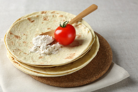 Stack of homemade whole wheat flour tortilla on napkin, on light backgroundの写真素材