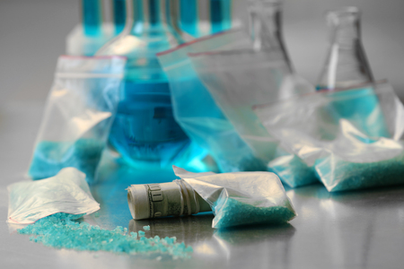 Drug laboratory: blue methamphetamine and money on table close upの写真素材
