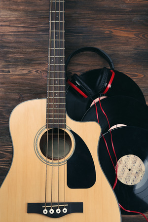 Guitar with vinyl records and headphones on wooden table close upの写真素材
