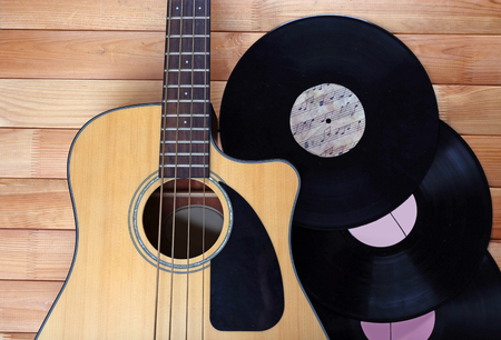 Guitar and vinyl records on wooden table close upの写真素材