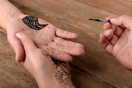 Process of applying Mehndi on female hand close upの写真素材