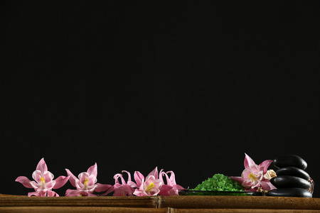 Beautiful spa composition with flowers and stones on black backgroundの写真素材