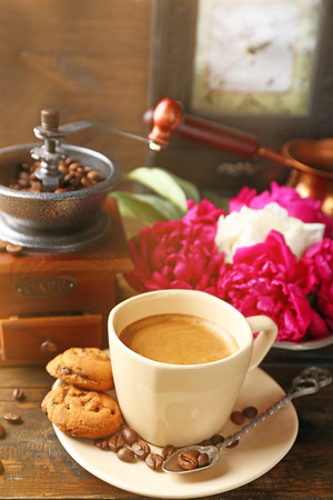 Composition with, coffee grinder, cup of coffee and peony flowers on wooden backgroundの写真素材