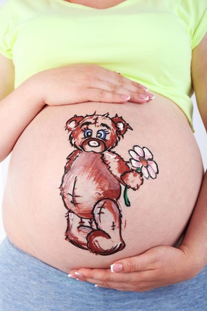 Body art on belly of pregnant woman on light backgroundの写真素材