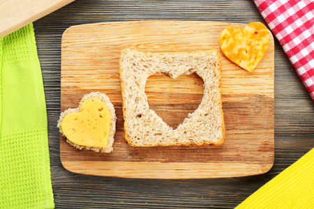 Bread slice with cut in shape of heart and cheese on table close upの写真素材