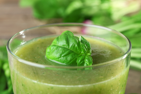 Glass of green healthy juice with spinach and peas on table close upの写真素材