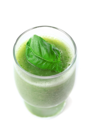 Glass of green healthy juice with basil isolated on whiteの写真素材