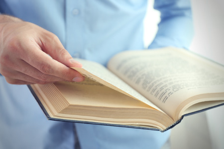 Young man reading book close upの写真素材
