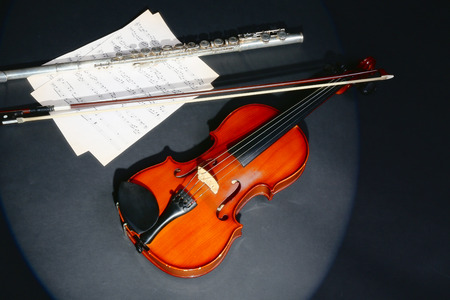 Violin and flute with music notes on dark backgroundの写真素材