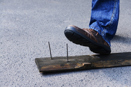 Worker steps on nail outdoorsの写真素材