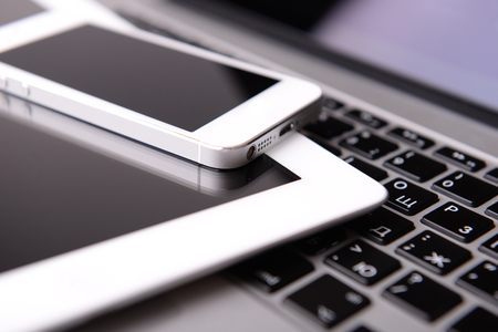 Tablet and mobile phone on keyboard, closeupの写真素材