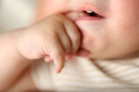 Baby finger in mouth, closeup