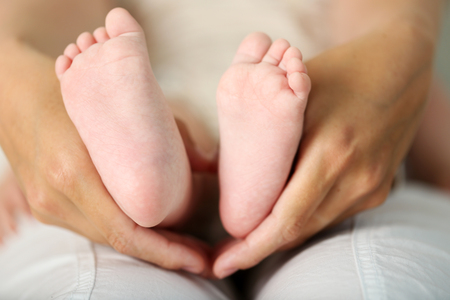 Adult hands holding baby feet, closeupの写真素材