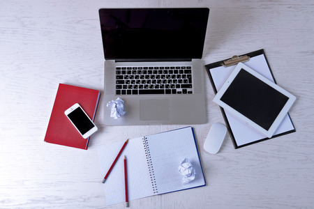 Office supplies and gadgets on white table, top view