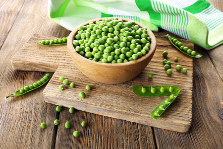 Fresh green peas in bowl on table close upの写真素材