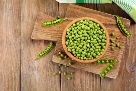Fresh green peas in bowl on table close upの写真素材