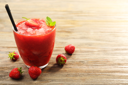 Glass of strawberry smoothie with berries on table close upの写真素材