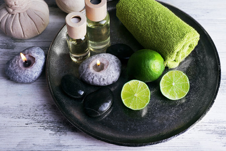 Beautiful composition of spa treatment on tray, on light background