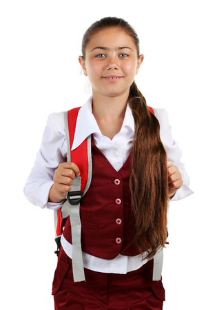 Beautiful little girl in school uniform isolated on whiteの写真素材