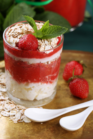 Dessert with fresh strawberry, cream and granola, on tray, on color wooden table backgroundの写真素材