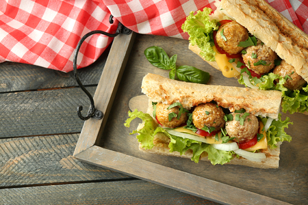 Homemade Spicy Meatball Sub Sandwich on tray, on wooden table backgroundの写真素材