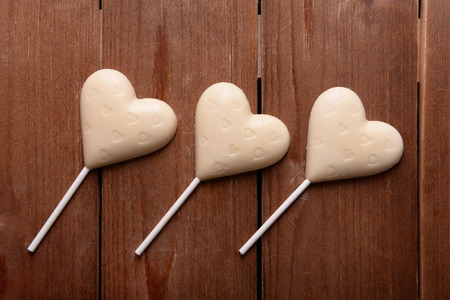 Chocolate candies in shape of hearts on wooden backgroundの写真素材